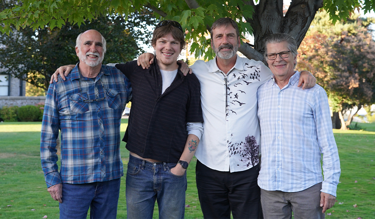 Jack Johnson, Sam Choman, Derek Sheffield, and Mike Choman stand together beneath a tree.