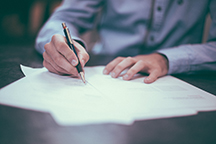 Person signing forms at a table