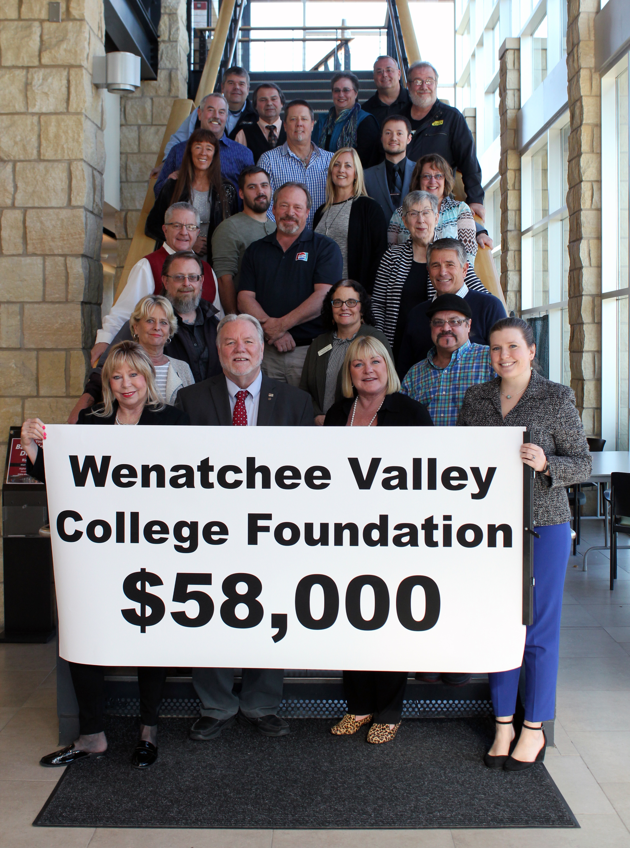 group photo holding sign with dollar amount