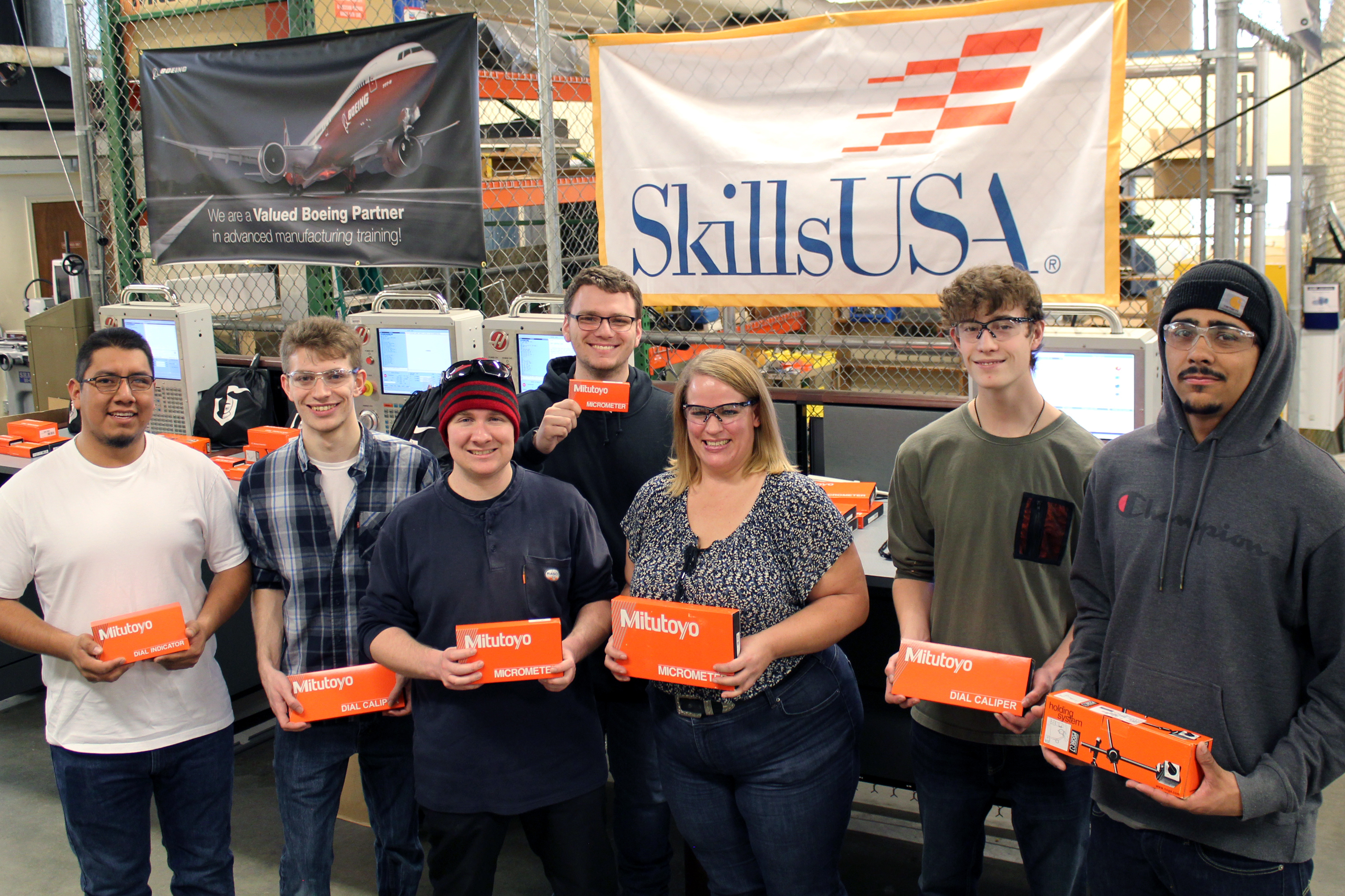 Students holding machining tools