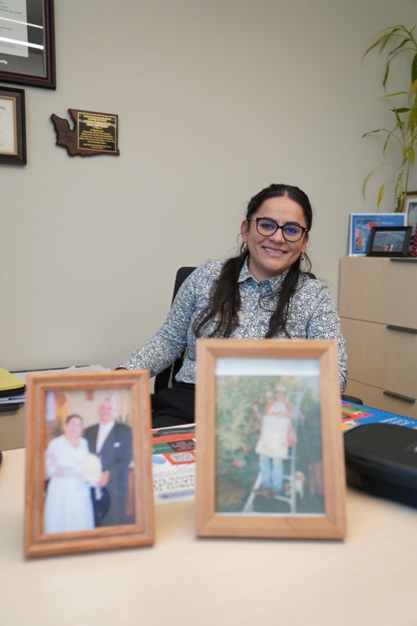 María at her desk with photos of her family members, including grandparents. 