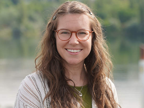 Ellen Bruex stands on a bridge overlooking a river.